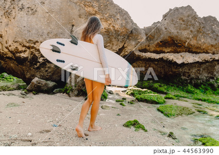 Surf woman with surfboard going to ocean 44563990