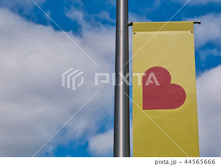 Flagpole with red heart on a yellow banner 44565666