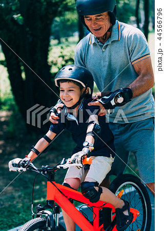 Grandfather and grandson biking in the park Grandfather and grandson biking in the park 44566796