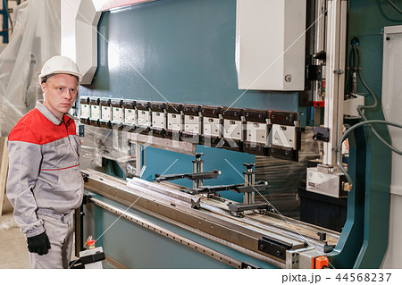 Tool and bending equipment for sheet metal. manufacture workshop. Workers adjusts the machine in the 44568237