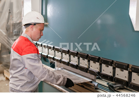Tool and bending equipment for sheet metal. manufacture workshop. Workers adjusts the machine in the 44568246