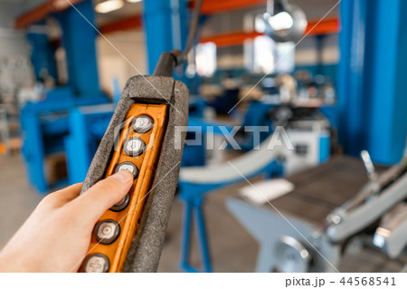 remote control of the crane on production. Workers working with a crane in the warehouse.. the remote control of the crane on production. Workers working with a crane in the warehouse.. the 44568541