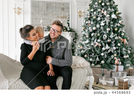 Happy family having fun at home. Christmas morning in bright living room. Young parents with little 44568693