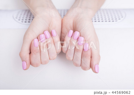 Gentle pink manicure. Female hands manicure salon 44569062
