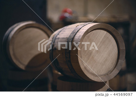 Wooden barrels in the old cellar in winery. barrels for wine with steel ring 44569097