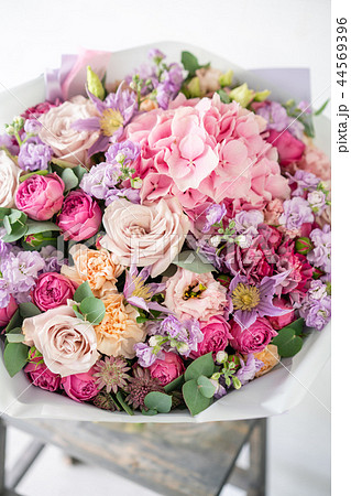 beautiful spring bouquet. flowers arrangement with various of colors in glass vase on old table 44569396