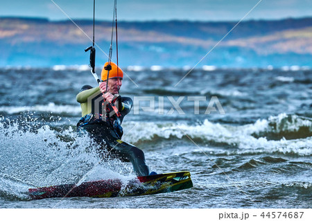 A male kiter slides on the surface of the water.  44574687
