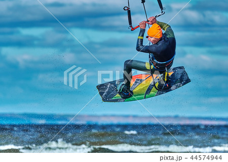 A male kiter jumps over a large lake. Close-up. A male kiter jumps over a large lake. Close-up. 44574944