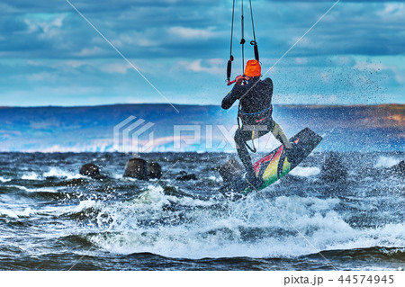 A male kiter jumps over a large lake. Close-up. A male kiter jumps over a large lake. Close-up. 44574945