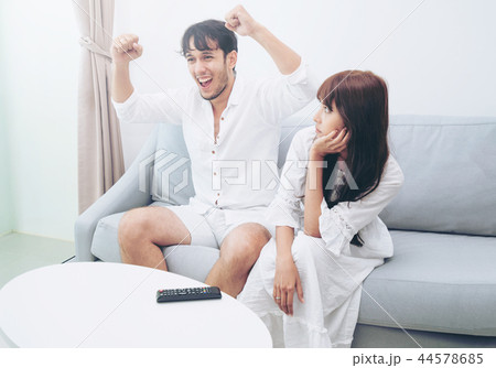 Happy young couple watching TV in living room. Happy young couple watching TV in living room. 44578685