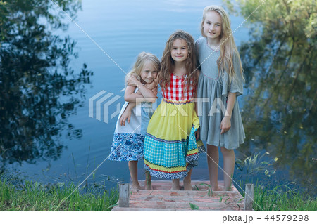 children on the riverbank / summer vacation merry girlfriends on vacation, sisters together on the river, friendship happiness family children on the riverbank / summer vacation merry girlfriends on vacation, sisters together on the river, friendship happiness family 44579298
