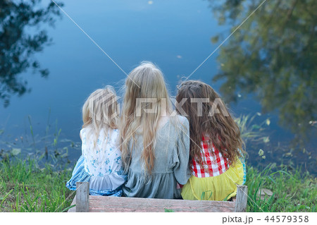 children on the riverbank / summer vacation merry girlfriends on vacation, sisters together on the river, friendship happiness family children on the riverbank / summer vacation merry girlfriends on vacation, sisters together on the river, friendship happiness family 44579358