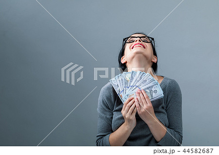 Young woman with a stack of cash USD 44582687