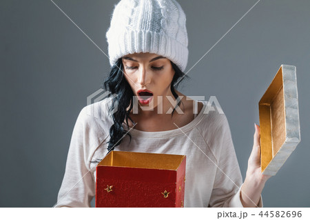 Young woman opening a Christmas present box 44582696