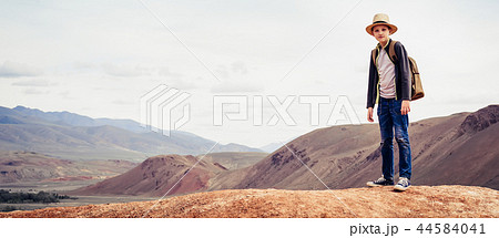 boy is traveler with backpack standing on mountain 44584041