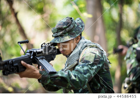 Squad of soldiers patrolling across deep forest. 44586455
