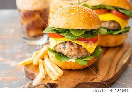 Street food, fast food. Homemade juicy burgers with beef, cheese and spinach on the wooden board. 44586641
