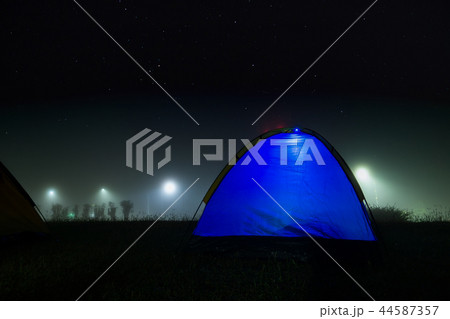 Blue tent with light in night and foggy. Blue tent with light in night and foggy. 44587357