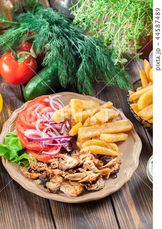 Greek gyros dish with french fries and vegetables Greek gyros dish with french fries and vegetables 44587489