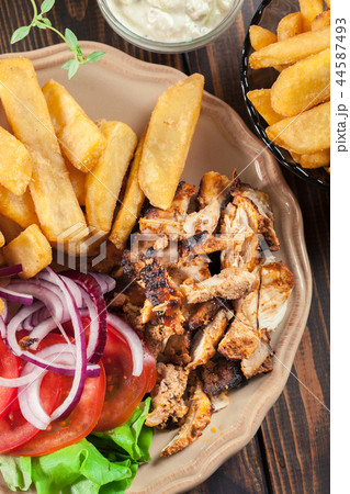Greek gyros dish with french fries and vegetables Greek gyros dish with french fries and vegetables 44587493