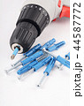 New screwdriver with screws and dowels close-up 44587772