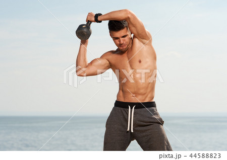 Portrait of young strong man training with kettle bell. Portrait of young strong man training with kettle bell. 44588823