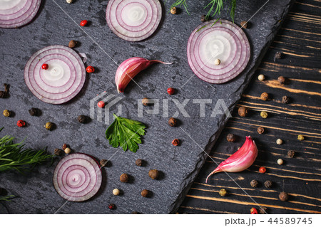 Pepper peas scattered randomly, onion, garlic and dill on a dark background 44589745