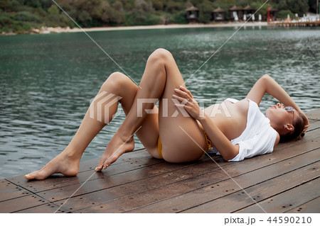 Sensual female lying on pier 44590210