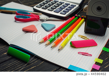 On the notebook there are pens, pencils, calculators 44590402