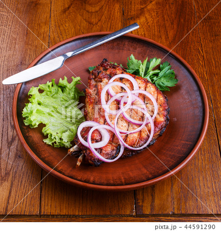 Juicy steak with onions, lettuce and parsley Juicy steak with onions, lettuce and parsley 44591290