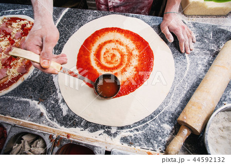 Cooking pizza. Imposition of tomato paste on the dough 44592132