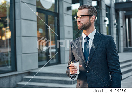 Quick coffee break. Good looking young man in full suit and glas 44592304