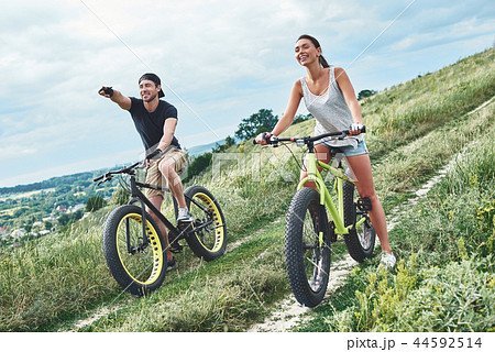 Look at it. A man and a woman are laughing and cycling Look at it. A man and a woman are laughing and cycling 44592514