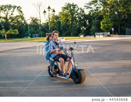 Lovely young happy couple driving electric bike Lovely young happy couple driving electric bike 44593608