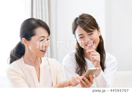 スマホを見る母と娘 スマホを見る母と娘 44593707