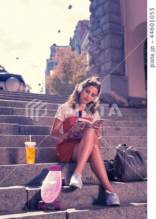 Young student girl sitting and reading book while waiting for her boyfriend Young student girl sitting and reading book while waiting for her boyfriend 44601055