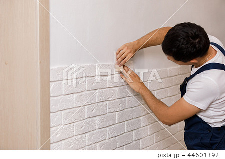 Professional Builder gluing decorative tile on wall. Professional Builder gluing decorative tile on wall. 44601392