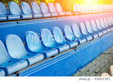 Empty plastic chairs in the stands of the stadium 44603365