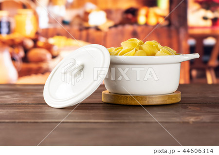 Raw yellow pasta conchiglie with rustic kitchen Raw yellow pasta conchiglie with rustic kitchen 44606314