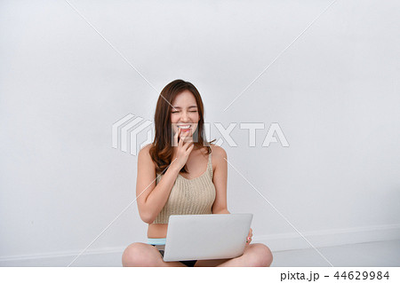 Beautiful girl in casual wear playing computer at home. Beautiful girl in casual wear playing computer at home. 44629984