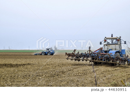 Lush and loosen the soil on the field before sowing. The tractor plows a field with a plow 44630951