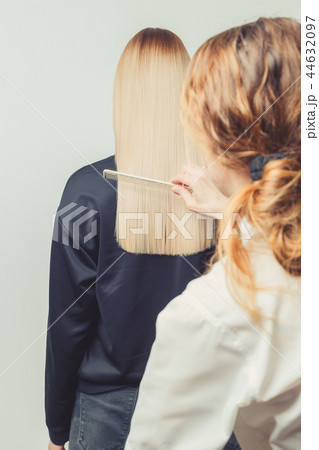 Hairdresser is combing long hair in beauty salon Hairdresser is combing long hair in beauty salon 44632097