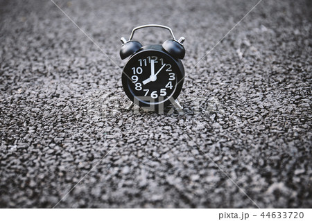 Alarm clock on the asphalt road texture background Alarm clock on the asphalt road texture background 44633720