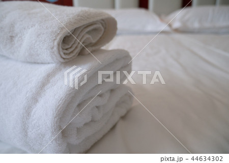 Folded stack of white towels in hotel guest room Folded stack of white towels in hotel guest room 44634302