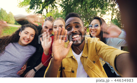 Point of view shot of cheerful students making online video call calling friends holding device Point of view shot of cheerful students making online video call calling friends holding device 44634983