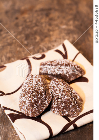 Chocolate madeleines lying on a towel on the old  44636639