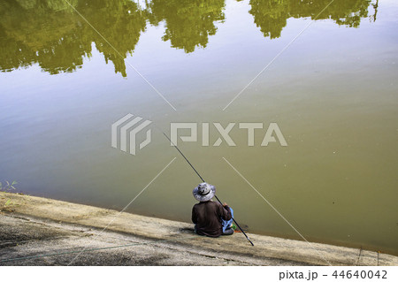 Man fishing by the river in the evening. Man fishing by the river in the evening. 44640042