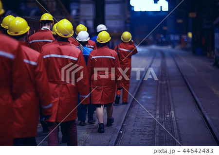 workers helmets at the factory, view from the back, group of workers, change of workers in the factory, people go in helmets and uniforms for an industrial enterprise workers helmets at the factory, view from the back, group of workers, change of workers in the factory, people go in helmets and uniforms for an industrial enterprise 44642483