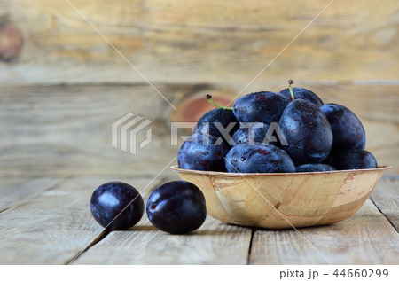 Ripe blue plums with drops of water 44660299