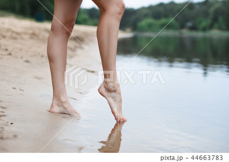 Beautiful female legs go into the water Beautiful female legs go into the water 44663783